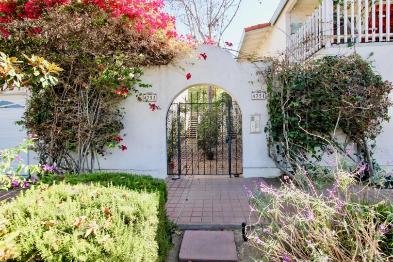 An entrance of a building in the Mission Villas II with beautiful plants.