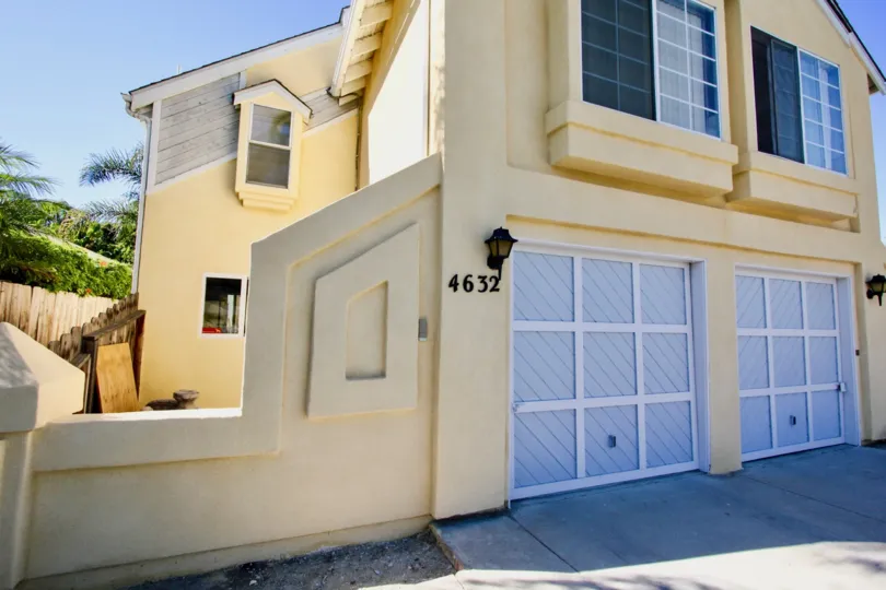 A beautiful yellow home with two garage doors located in the Normal House II Community.