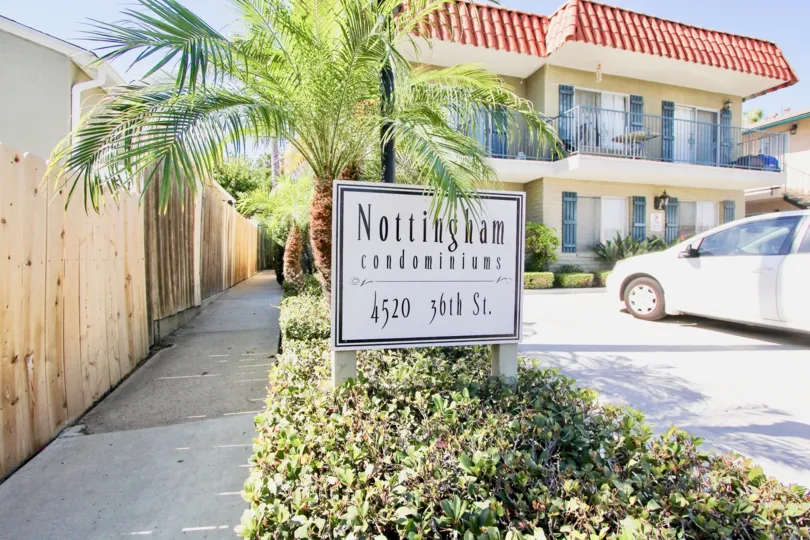 The address plate of a Nottingham community looks out onto a parking lot and building, in Normal Heights, CA.