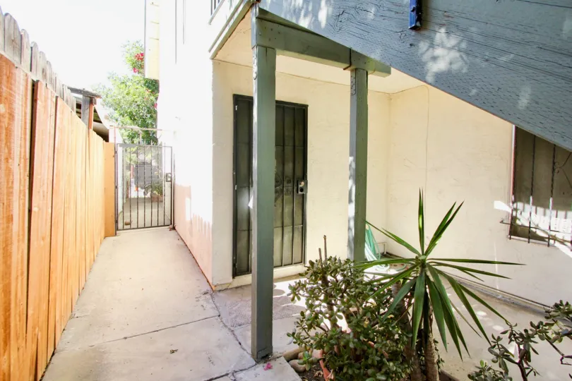 THE BUILDING IN THE OAKTREE VILLAS WITH THE OAK TREE, PLANTS, WOOD WALL, STEEL GATE