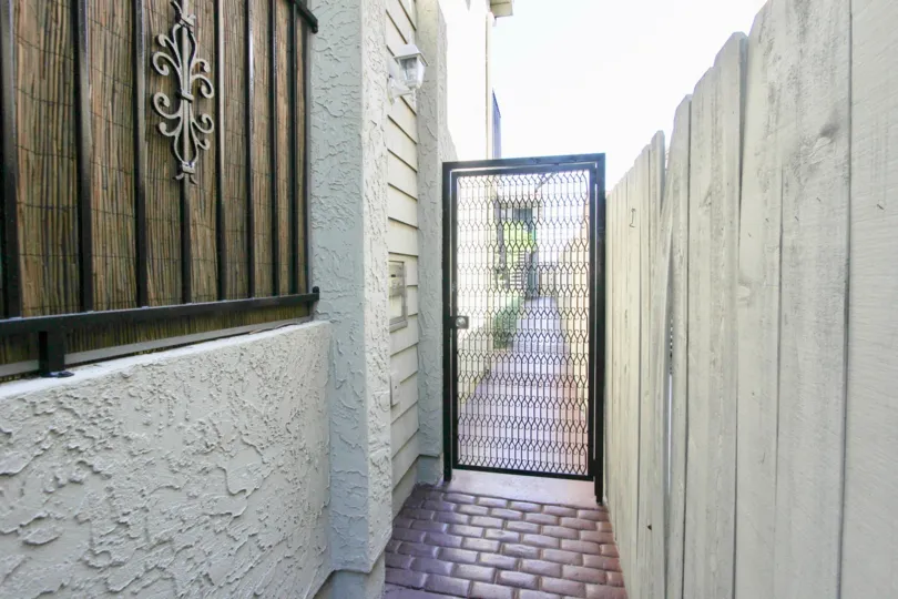 There is a narrow ally way. The ally way is blocked by a door and seems to be connected to the private property.