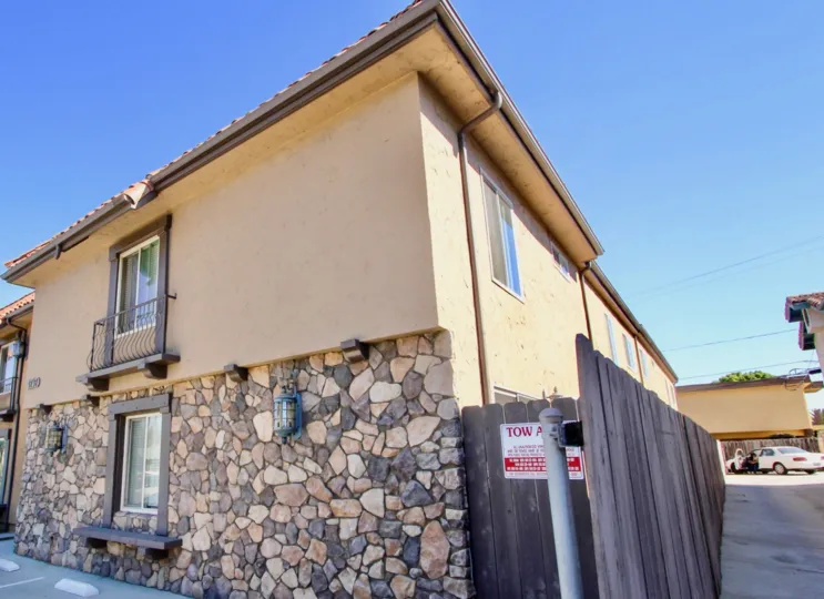 Side of apartment building with parking lot and wooden fence On 34th in Normal Heights, Ca.