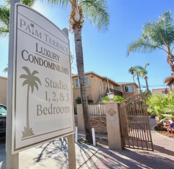 THE PLAM TERRACE CONDOMINIUMS IN THE PALM TERRACE WITH THE NOTICE BOARD, LAMP, TREES, PLANTS