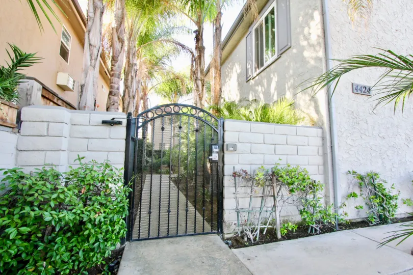 Security gate leading to the lush and well tended gardens and common walkway between the homes in Palm Villas of Normal Heights, California