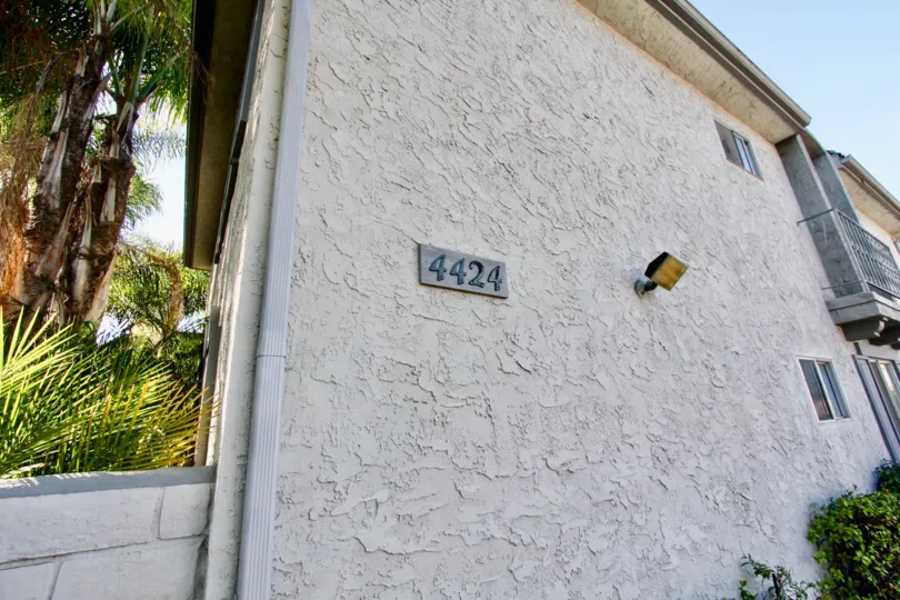 A sunny day in the area of Palm Villas, light, house number, condo, outside, trees, bush, balcony