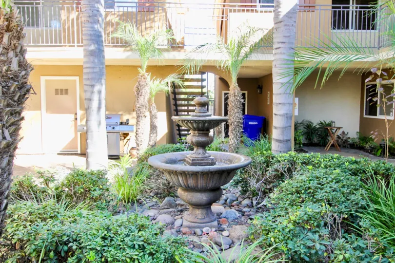 A sunny day in the area of Stone Manor, Outside, palm trees, fountain, stairs, balcony