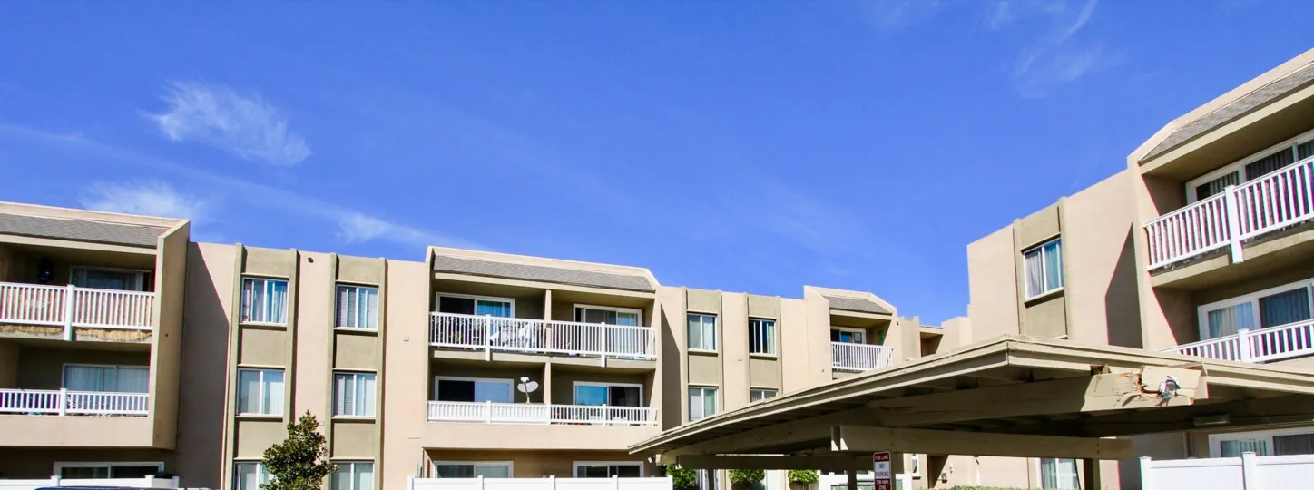 A sunny day in the area of Suncrest Villas, outside, balconies, fence, bushes, balcony
