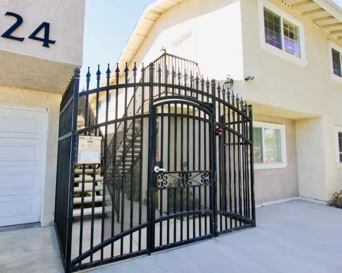 A sunny day in the area of The Bentley, gated entrance, stairs, sidewalk, windows