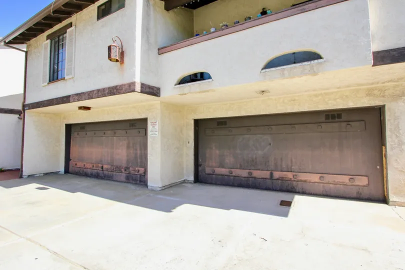 The front of a house in Tiffany Square, Normal Heights, California, with garage doors and balcony