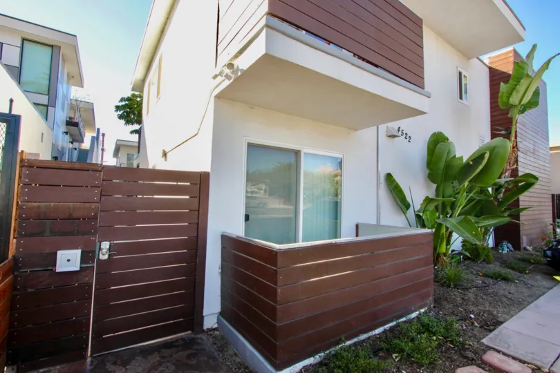NICE HOUSE IN FRONT OF BROWN COLOUR GATE AND THE TREES ARE VERY CUTE