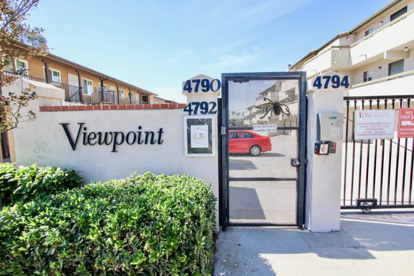 The entrance to the Viewpoint community with white-washed signage and a parking lot.