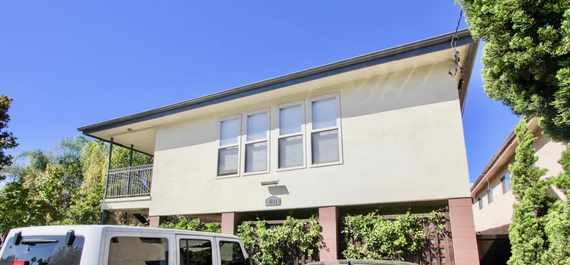 A white van is parked outside of a large house in West Mountain View Condos.