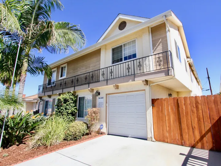 A house located in Wilson Villas in Normal Heights, California. Shows a balcony, fence, garage, and a driveway