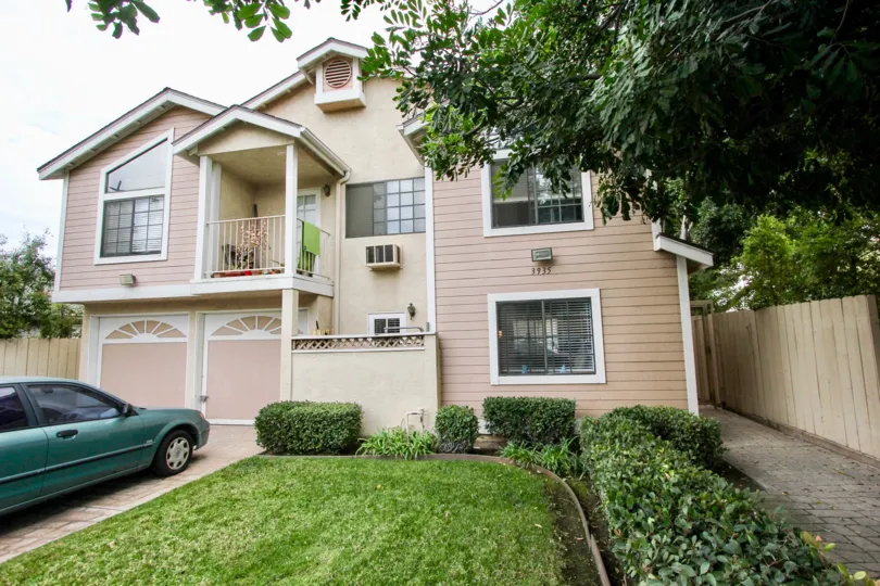 A beautiful two story house with a lawn bushes and a two car garage at the 32nd street condos North park California