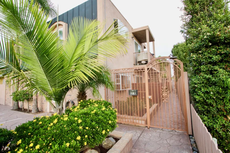 Residential Apartment Building with front gate, palm tree and bushes