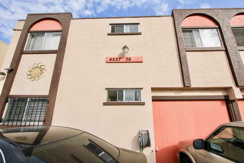 Three story pink and brown building with a light on it's side at 36th Street Condos in North Park CA