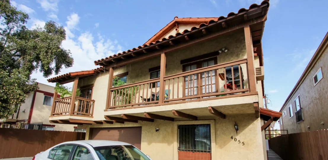 Front of house with two balconies, garage door in first floor in the 36th Street Villas