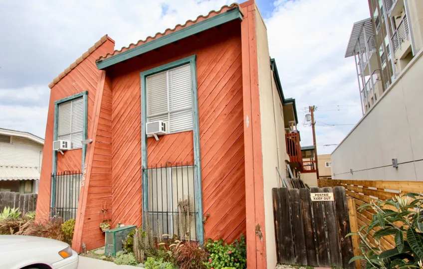 Two level apartments with wooden siding and air conditioners at 3965 Iowa St in North Park, California.