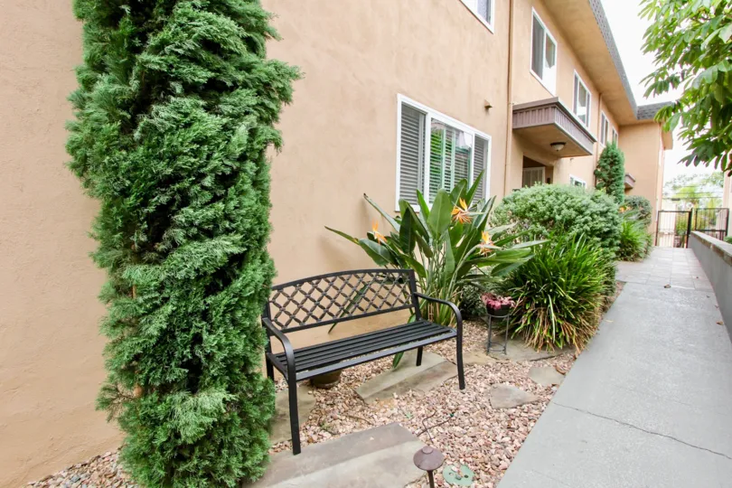 Exterior of apartment building at 4154 Louisiana Street with bench and plants
