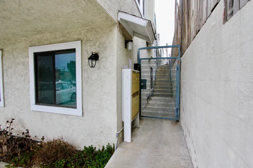 Secure gated entrance between two buildings, and mailboxes, at Alabama Terrace community in North Park, CA