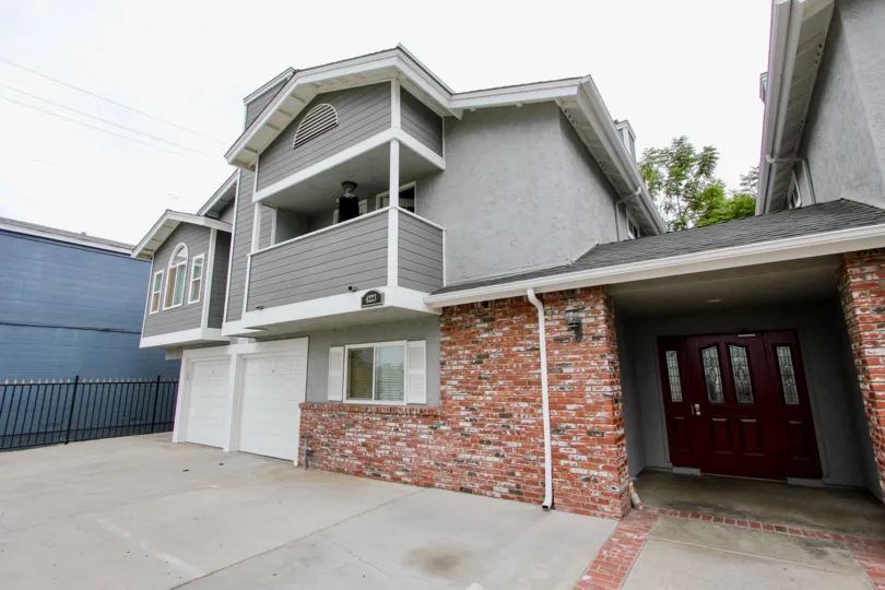 Front of a house of two levels with two garage doors and balcony in the Arizona Gardens