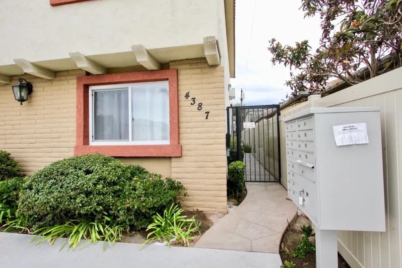 The corner of an apartment complex near some plants in the Bella Villaggio Community in North Park, California