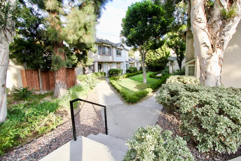Lush green lanscaping and trees leading into the California Village community in North Park, California.