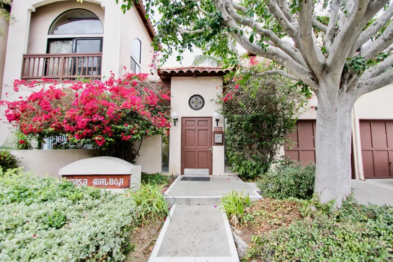 A 2 story, cream colored home with brown detailing and colorful landscaping in Casa Balboa, North Park, California.