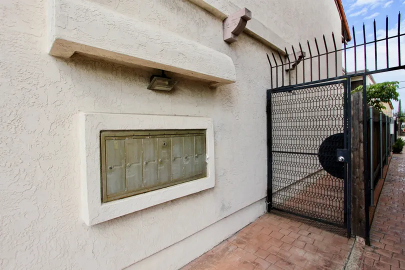 A sunny day in the community of Casa de 33rd with brick paving and decorative fencing in North Park, California