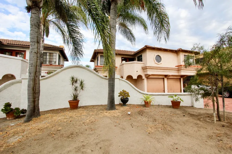 Beautiful palm trees and a sand with a big house in the back