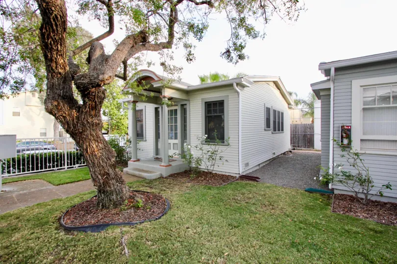 View of house with tree in the front yard in the Colonial Court