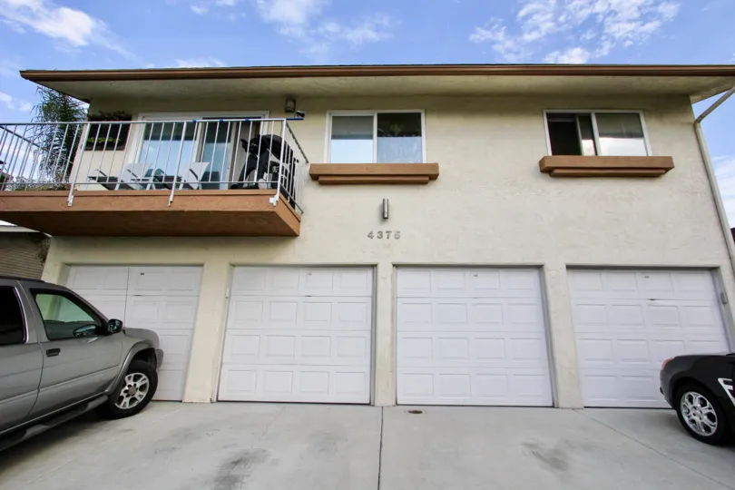 Four white garage doors on a brown two story building at Felton Terrace inside North Park CA