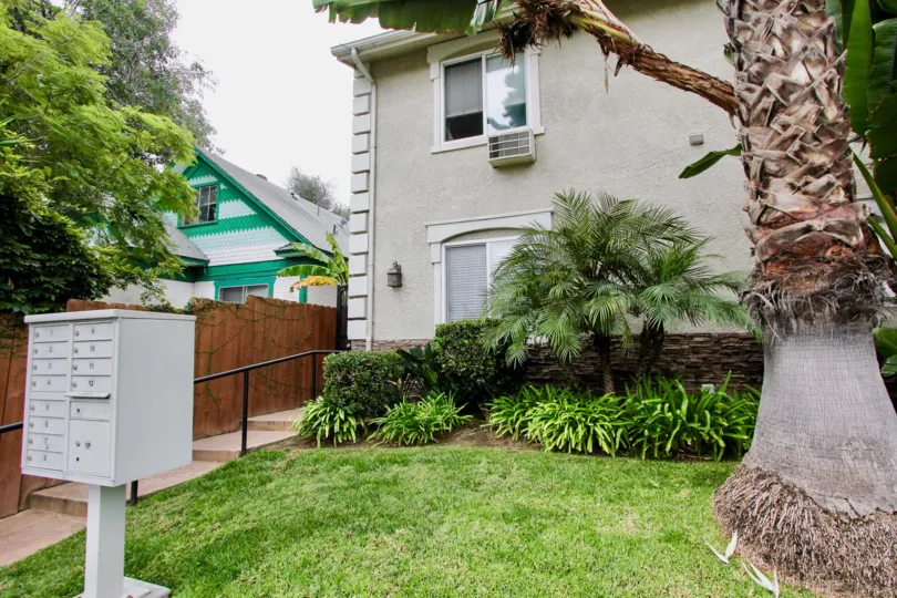Daytime, front view of apartments including yard and trees in Florida Gardens.