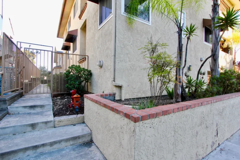 Florida Manor community living in North Park, California: outdoor view of multi-story stucco building with palm trees.