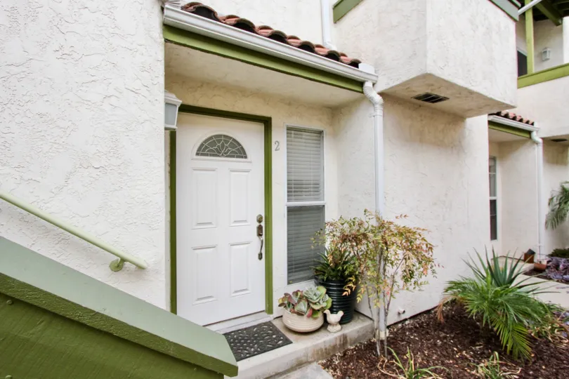 View of a main door of a house with green frame and with white door in the Grim Townhomes