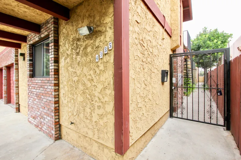 Corner picture of building wall, showing number of building and side gate