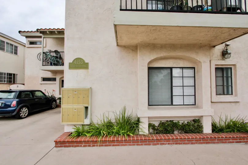 Beautiful pinkish stucco apartments at Idaho at the Park in North Park, CA