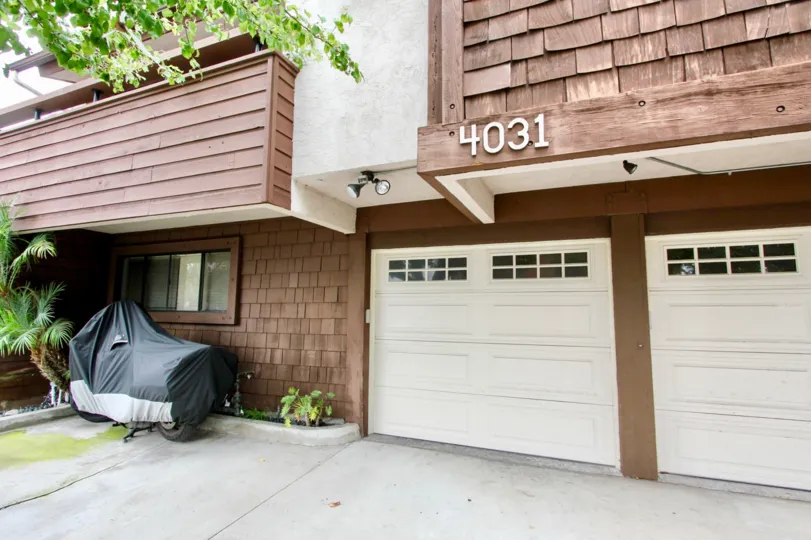 A brown shingled home with a two car garage in Idaho Street Condos in North Park, California