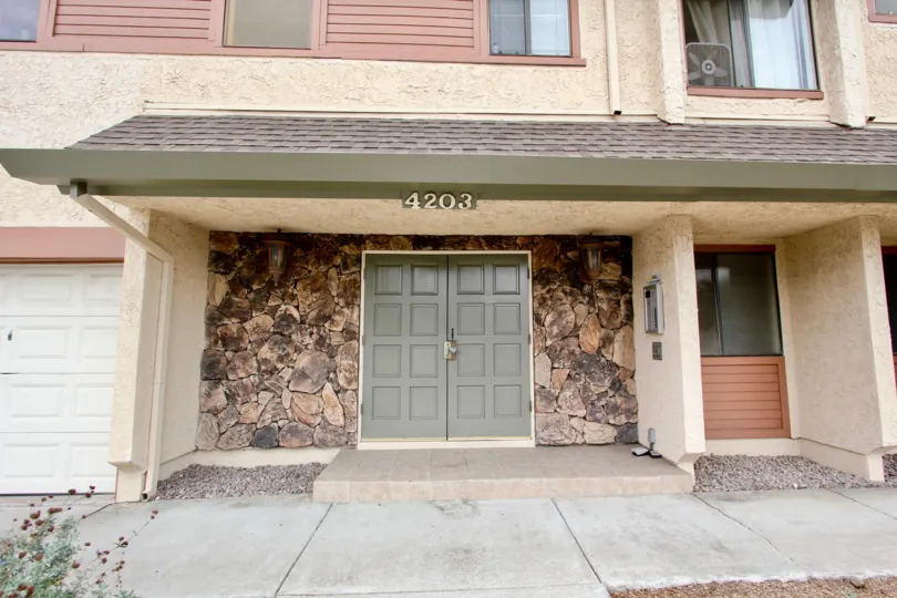Front entrance of Idaho Villas featuring stone facade and double doorways next to double garage.