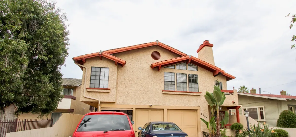 Beige stucco unit with 3 garages located at Illinois Park Condos in North Park, California