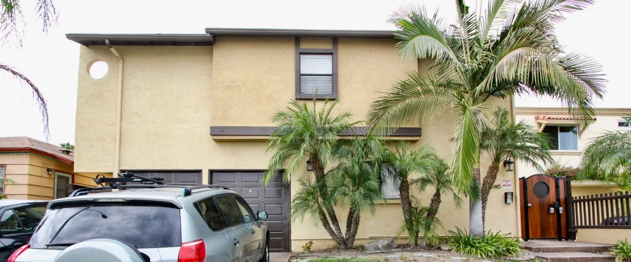 Polished wooden gate with palm trees in Iowa Street Condos.