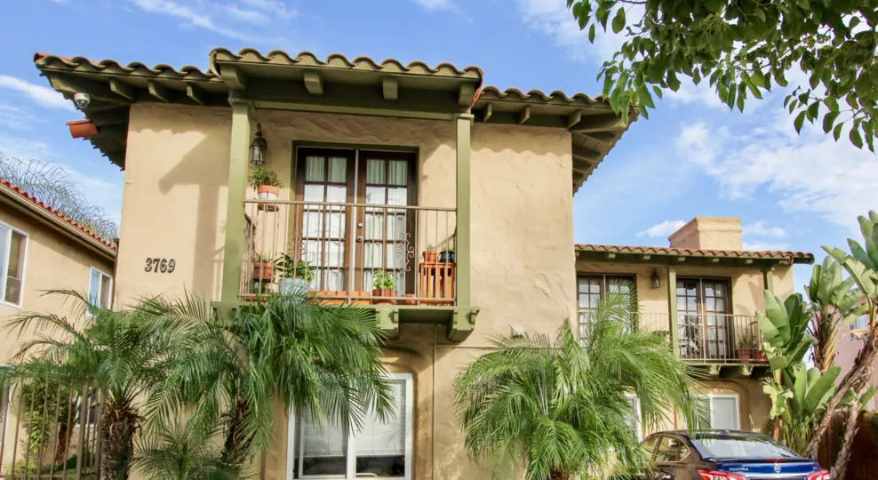 Two story residential building surrounded by palm trees at La Hacienda in North Park California