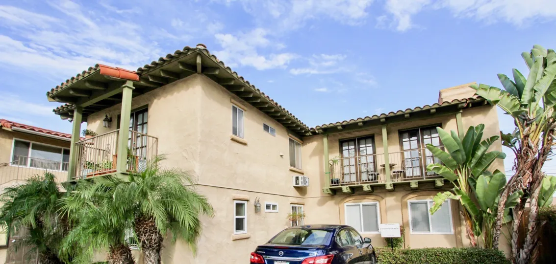View of a house with balconies and a lot plants in the front yard in the La Hacienda