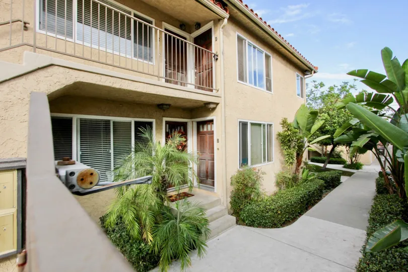 Plants and bushes are covered through the pathway and has balcony
