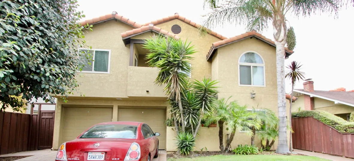 Two storey house with double garage and Palm trees in front in Las Palmas, North Park, California