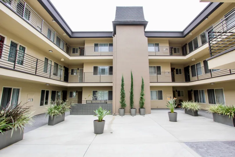 Walkways between the the condos at Louisiana Condominiums open to an open patio with plants in North Park, CA.