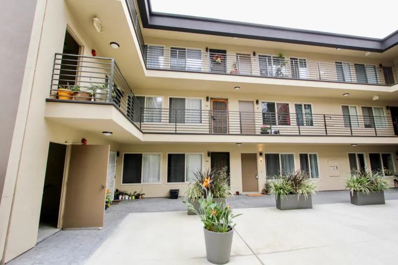 Front of a residence of three floors and balconies to main patio, with little flowers in the Louisiana Condominiums
