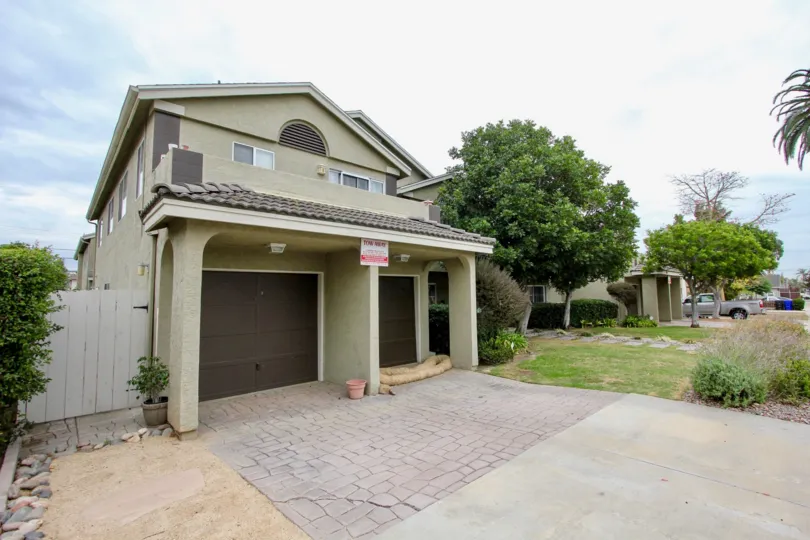 A large villa with a garage and a large front porch with a garden in the Louisiana Village Bayside Community in the North Park, California