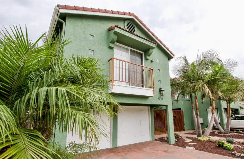 A two story green exterior house at Majestic Palms located in North Park, CA