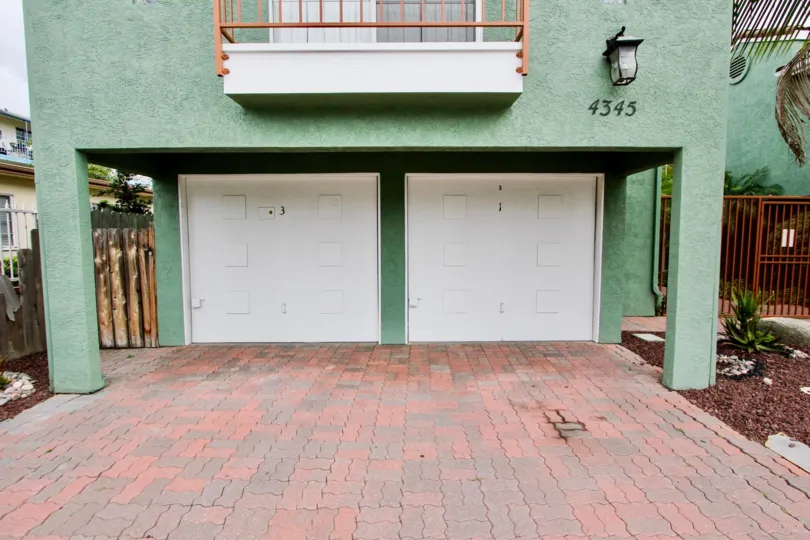 The exterior of 4345 Majestic Palms in North Park showing a balcony and garage doors
